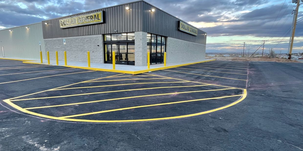 Empty parking lot of a Dollar General store at dusk.