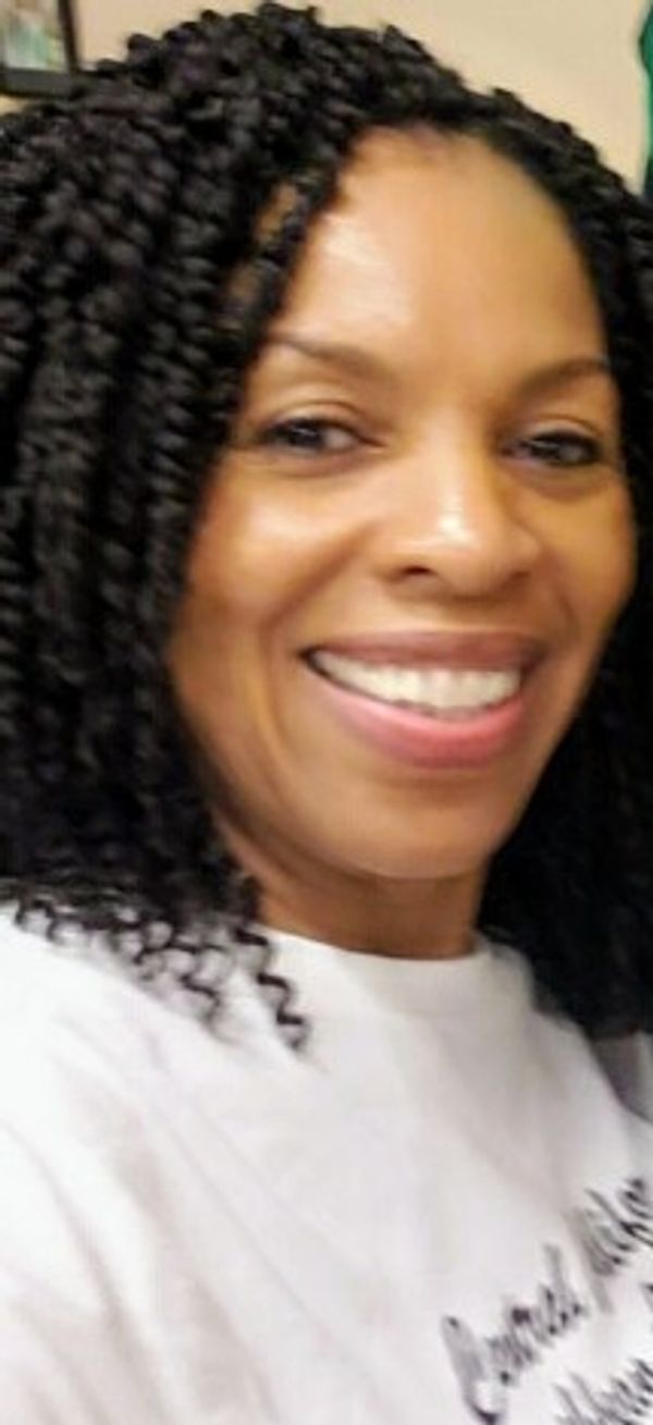 Close-up of a smiling woman with braided hair.