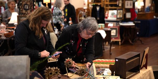 Two woman shop at the Christmas in Smithfield Antique Show