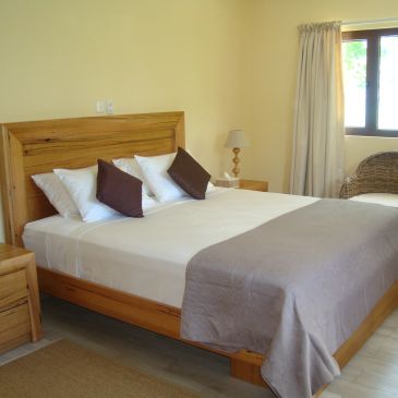 Cozy bedroom with wooden furniture and neutral tones.
