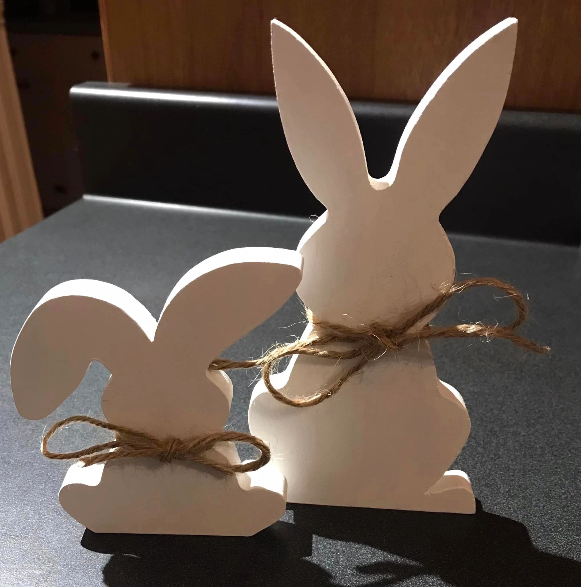 set of 2 wooden white bunnies with string around necks