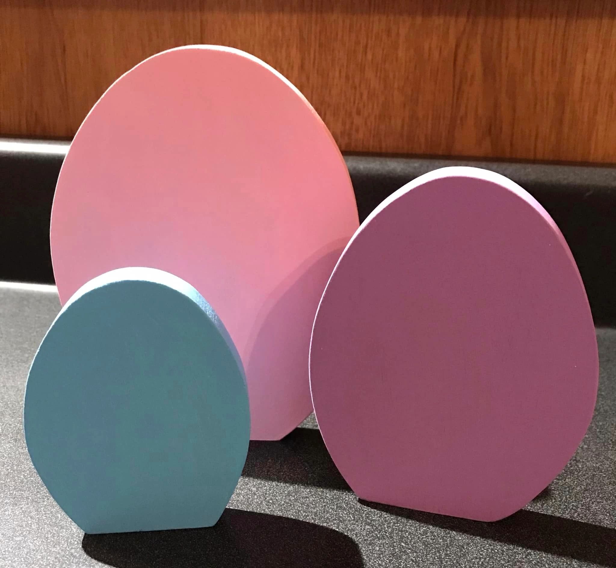 3 wooden shaped eggs in pink, blue and purple