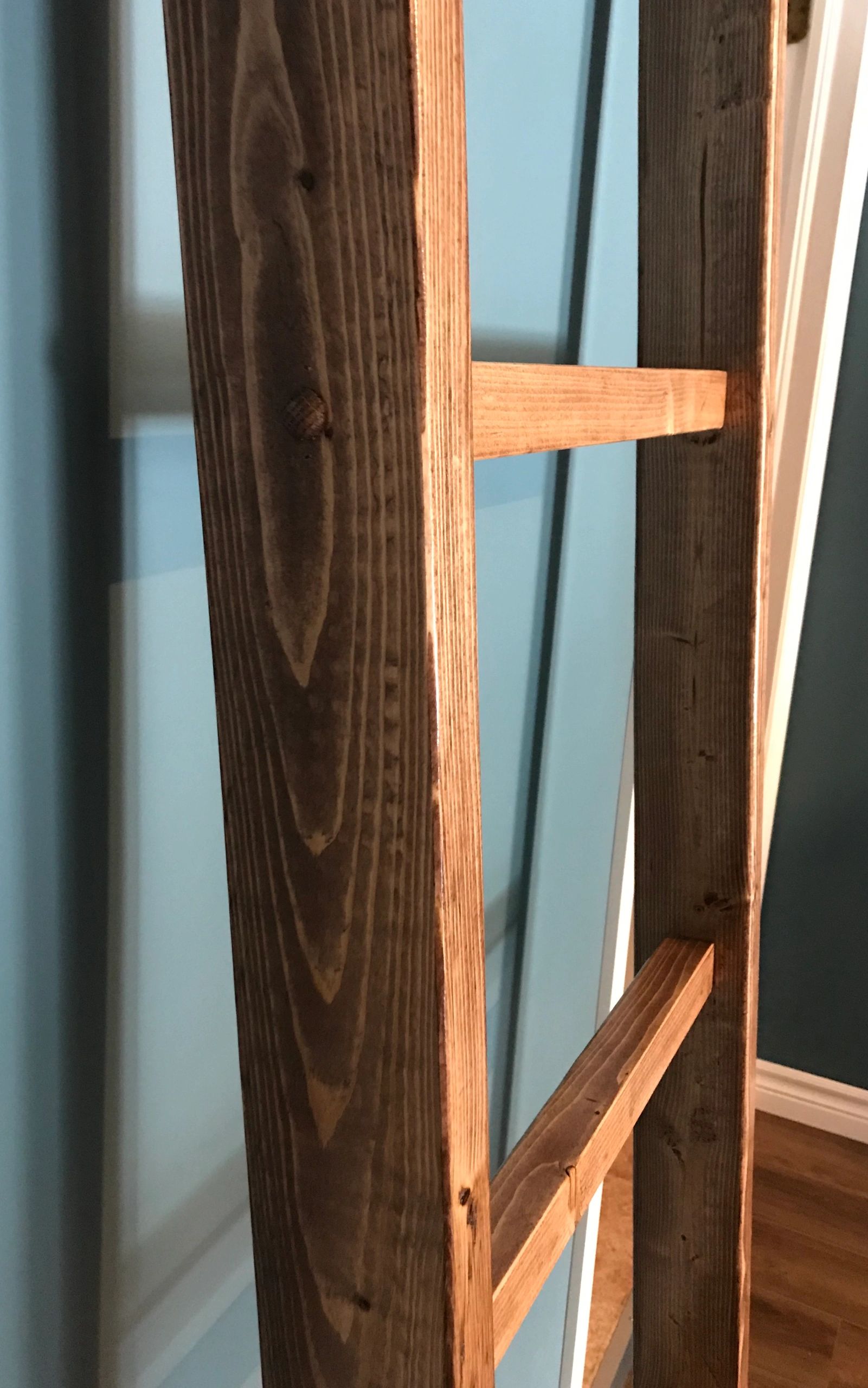 walnut blanket ladder against a blue wall