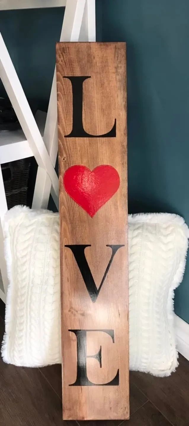 Wood board with the word love on it and the O is replaced with a red heart