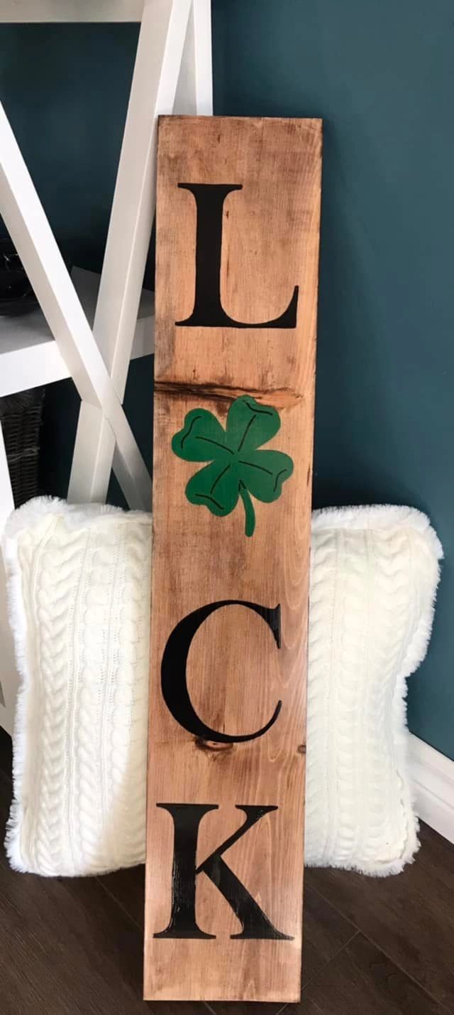 Wooden board with Luck painted on it. Instead of the U it is a green shamrock