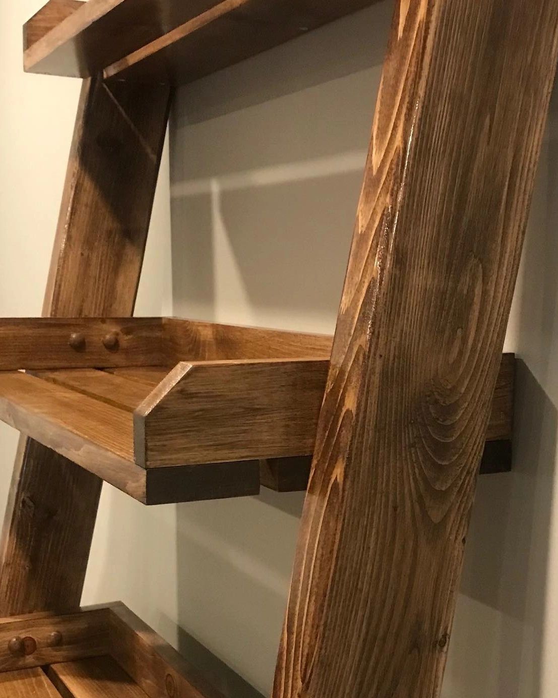 bathroom shelf ladder in walnut against a cream colored wall with 2 shelves