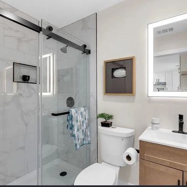Modern bathroom with glass shower and vanity.