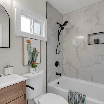 Modern bathroom with white decor and cactus artwork.