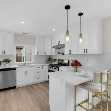 Modern white kitchen with island and bar stools.