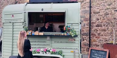 Woman ordering coffee from a charming vintage coffee trailer.