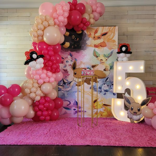 Colorful Pokémon-themed birthday setup with balloons and a lighted number 5.