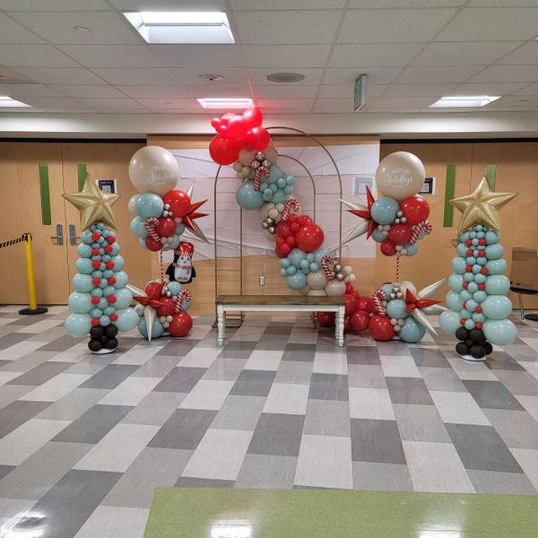 Festive balloon arrangement with holiday-themed decorations and a bench.