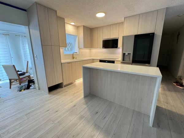 Modern kitchen with light wood cabinets and a central island.