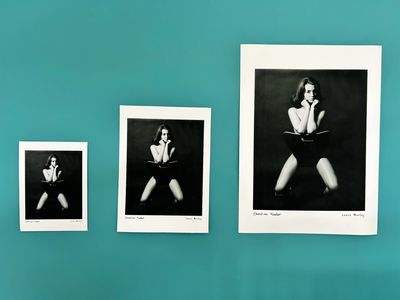 Three black and white portraits of a woman against teal wall.