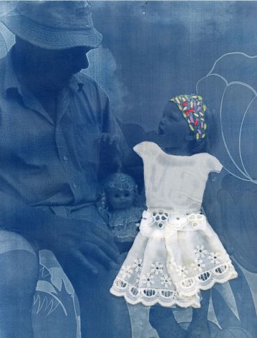 Man holding a baby doll dressed in white.