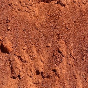 Close-up of reddish dirt or clay surface.
