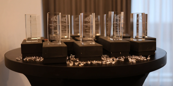 Crystal awards displayed on black boxes atop a round table, surrounded by decorative gems.