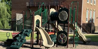 Children's playground with slides, climbing structures, and a playhouse area.