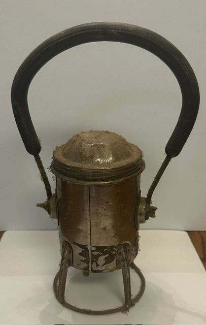 Vintage dusty lantern with a curved handle.