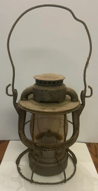 An old rusty metal lantern with a handle.