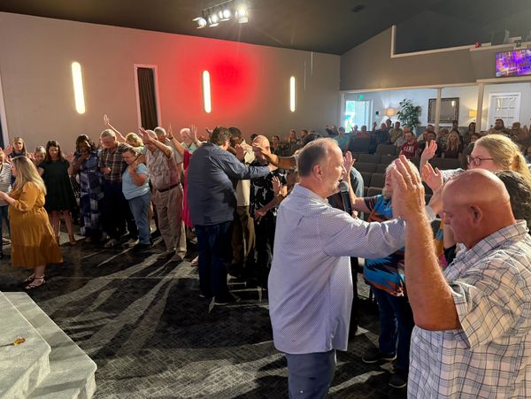 People gathered in a church group prayer or blessing.