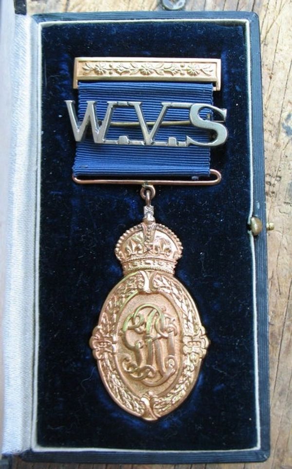 A vintage W.A.V.S. medal with ornate design in a presentation case.