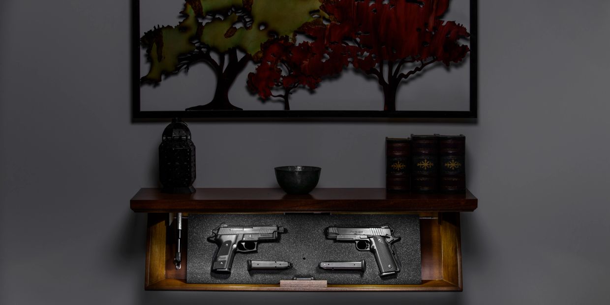 Wood TacticalTrap shelf mounted on wall in dark room and open with light on in the drop down display