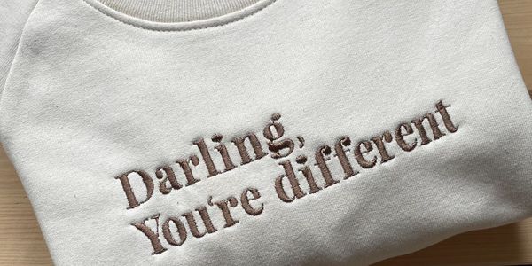 organic vanilla bean coloured sweat with the words darling you're different, mocha coloured font