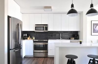 photo of modern kitchen incasing fridge, oven, sink and bench top