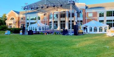 Large stage, enclosed tents with clear windows, school event 
