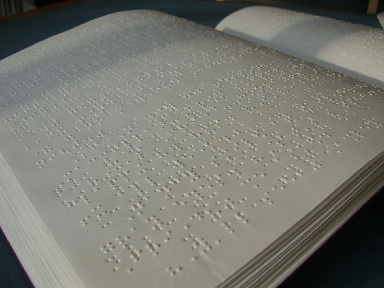 Book with braille on the pages on a black background.