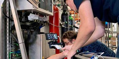 Two people working with industrial machinery.