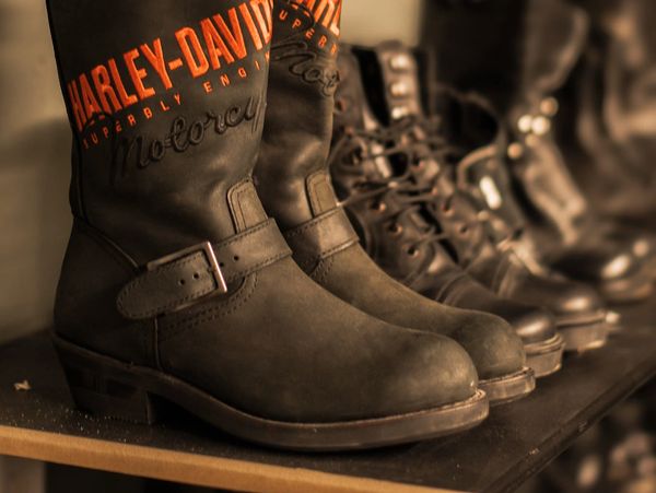 Black Harley-Davidson motorcycle boots on a shelf.