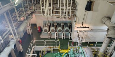 View inside an industrial engine room with large machinery and ducts.