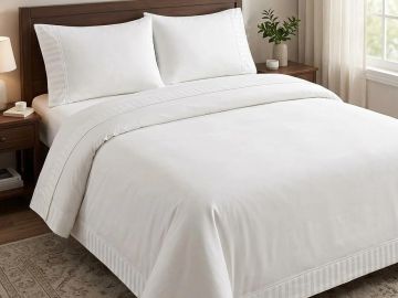 Neatly made bed with white bedding in a cozy bedroom.