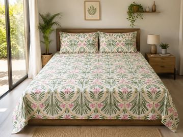 Bed with floral-patterned bedspread in a bright room.