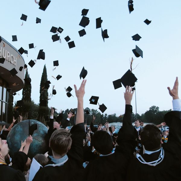 Graduates throwing caps in the air outdoors.