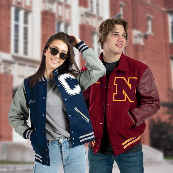 Two young adults in varsity jackets outdoors