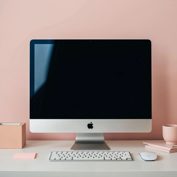 Minimalist workspace with an Apple iMac and pastel decor.