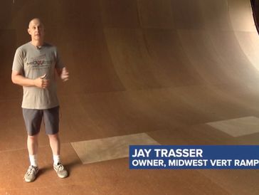 Jay Trasser standing on a vert ramp inside a skatepark.