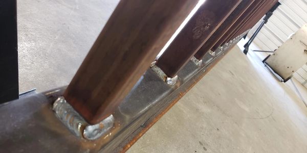 This image showcases sturdy, precision welds joining vertical metal bars to a horizontal base.