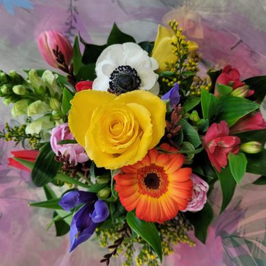 A vibrant bouquet with yellow rose and multicolored flowers.