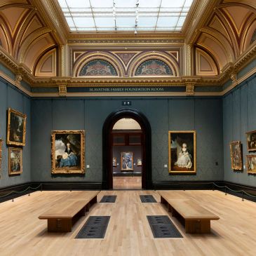 Museum gallery with classical paintings and benches.