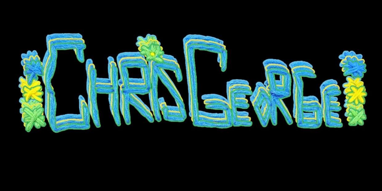 Colorful embroidered text with floral decorations on black background.