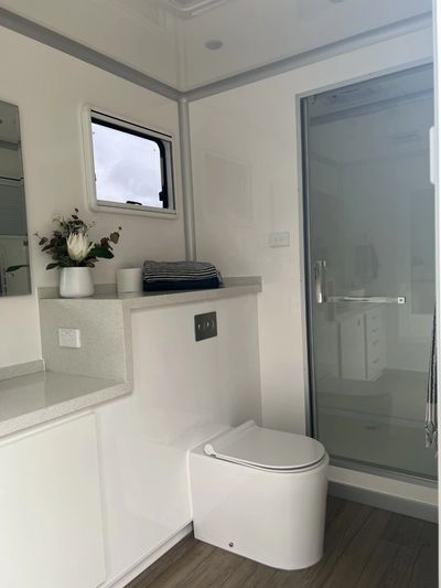 Inside our spacious portable bathroom boasts a full-sized enclosed shower for ultimate comfort