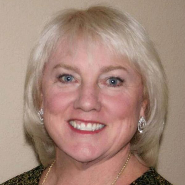 Smiling middle-aged woman with blonde hair and blue eyes.