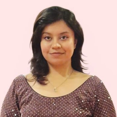 Woman in a sparkly brown dress smiling gently.