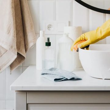 person using gloves cleaning a bathroom