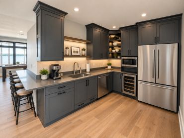 Modern kitchen with gray cabinets and stainless steel appliances.
