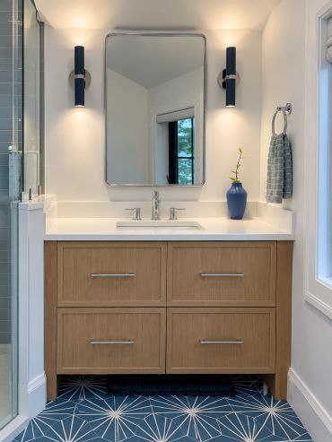 Minimalist bathroom vanity with wooden drawers and blue accents.
